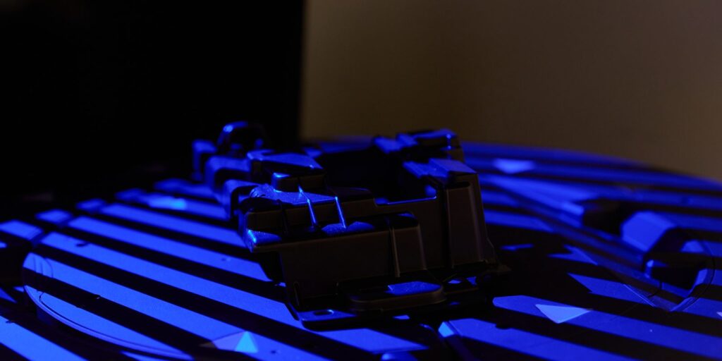 Black molded part on a blue-light 3D scanner turntable for dimensional checks