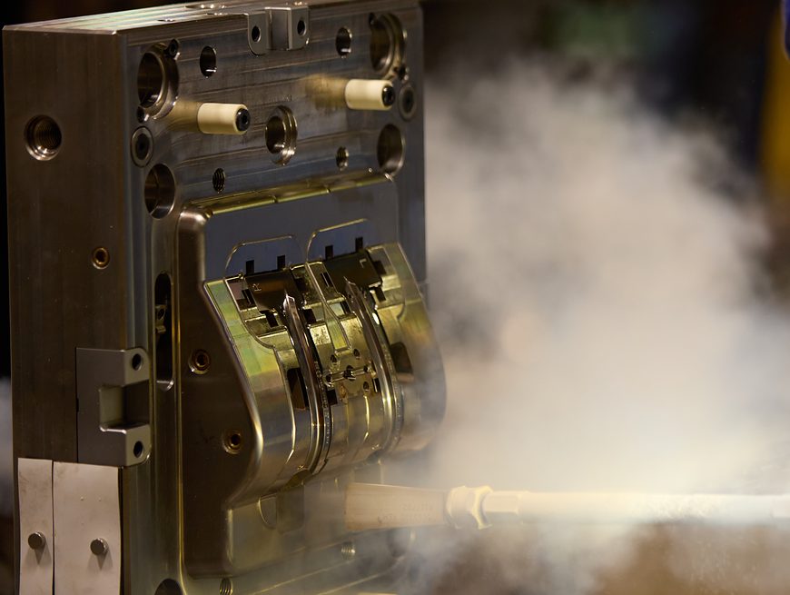 Dry-ice blasting cleans a polished two-cavity injection mold during maintenance